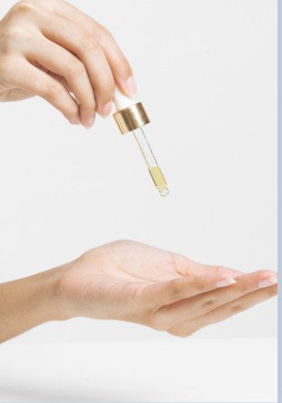 Face oil dropper over open palm