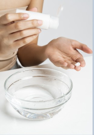 Cleanser being dispensed over a glass bowl of water