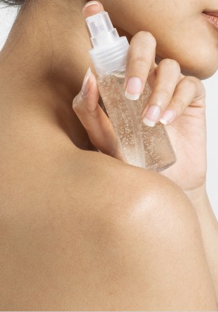 Body mist being sprayed on shoulder